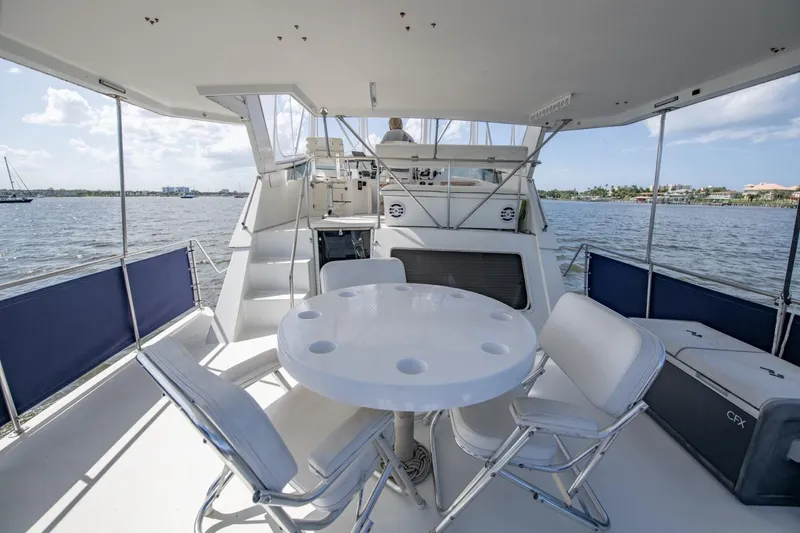 Slide: The Image of 1988 Tollycraft 44 Cockpit Motor Yacht with outdoor seating, overlooking serene waters. - 40