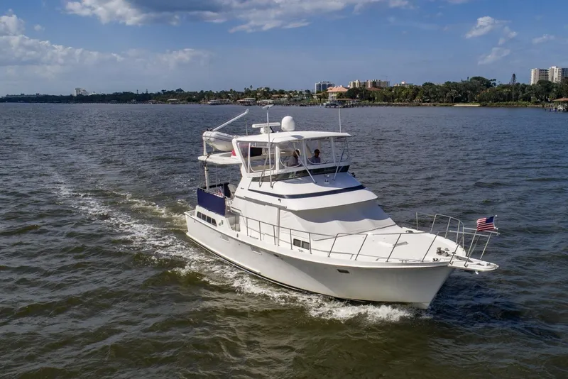 Slide: The Image of 1988 Tollycraft 44 Cockpit Motor Yacht cruising on a sunny day with scenic shoreline. - 10