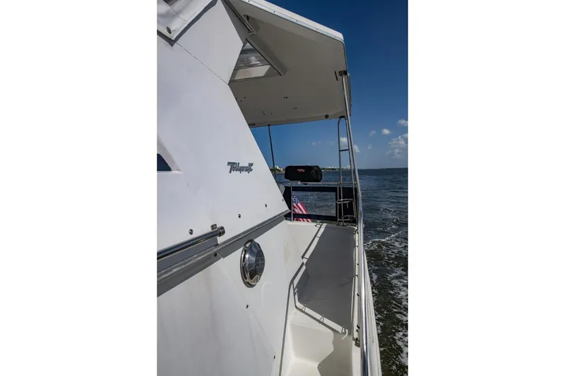 Slide: The Image of 1988 Tollycraft 44 Cockpit Motor Yacht cruising on open water under clear blue skies. - 62
