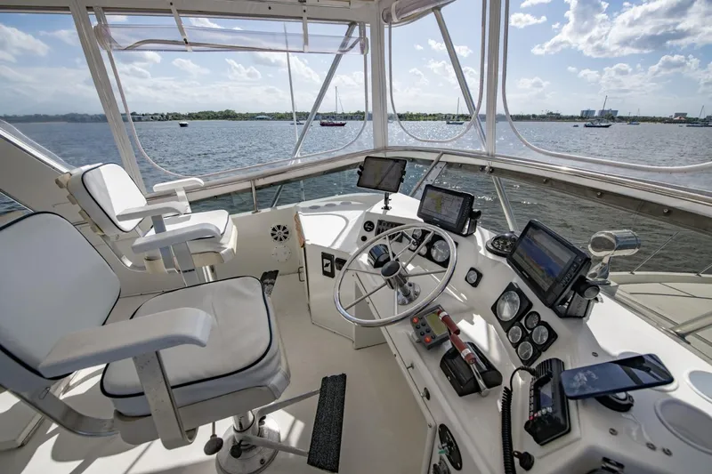 Slide: The Image of 1988 Tollycraft 44 Cockpit Motor Yacht helm with navigation equipment, overlooking serene waters. - 52