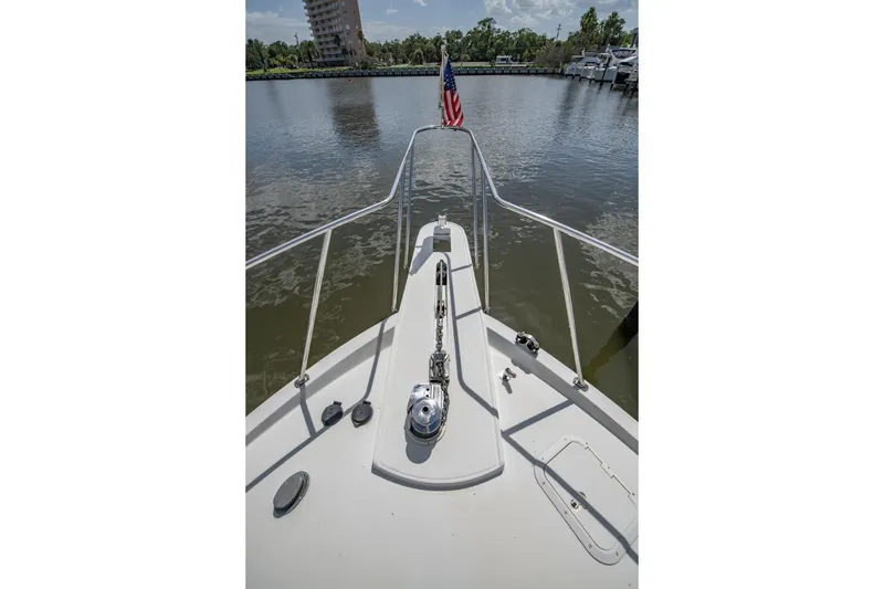 Slide: The Image of 1988 Tollycraft 44 Cockpit Motor Yacht bow with American flag on calm water. - 35