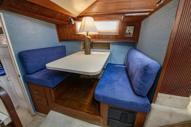 Slide: The Image of 1988 Tollycraft 44 Cockpit Motor Yacht interior with blue cushioned seating and table lamp. - 25