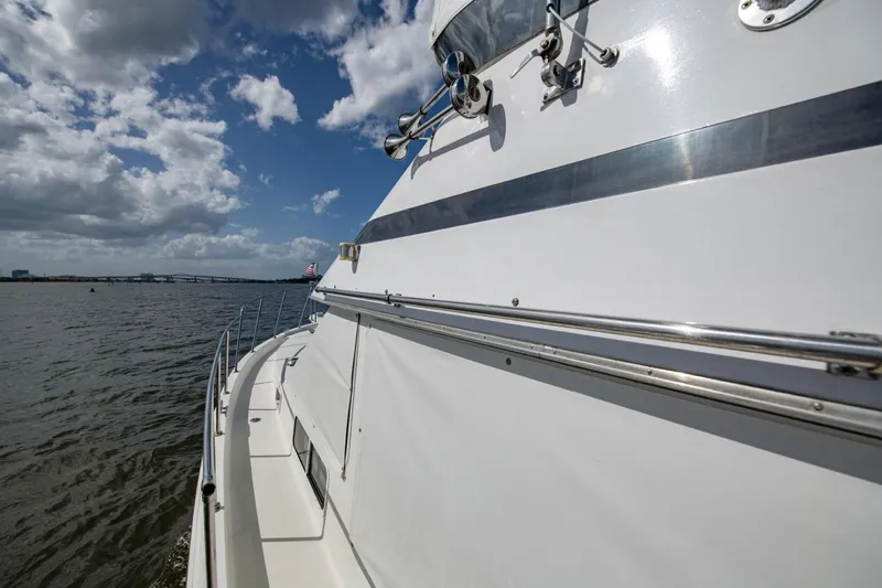 Slide: The Image of 1988 Tollycraft 44 Cockpit Motor Yacht cruising on a sunny day with cloudy skies. - 57