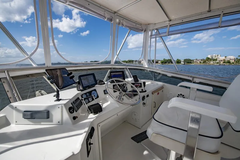 Slide: The Image of 1988 Tollycraft 44 Cockpit Motor Yacht helm with navigation equipment, overlooking serene waters. - 53