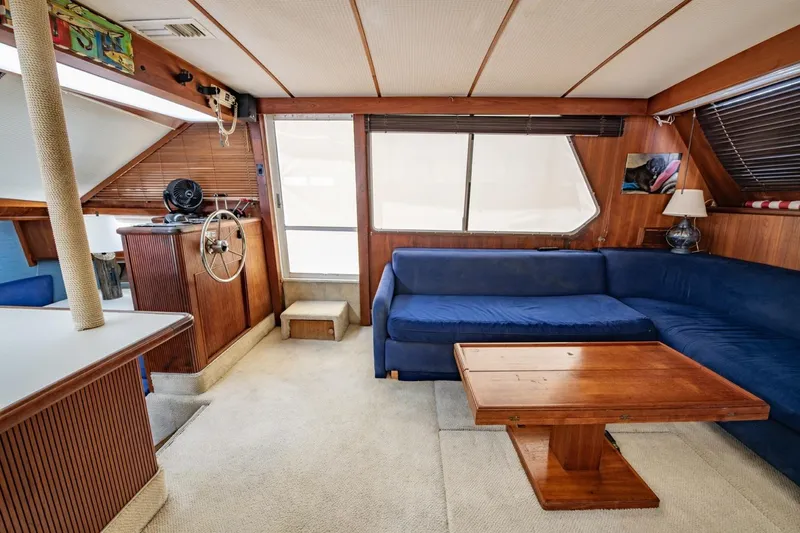 Slide: The Image of 1988 Tollycraft 44 Cockpit Motor Yacht interior with blue seating and wooden accents. - 15