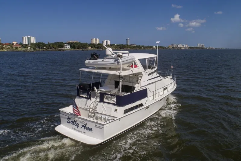 Slide: The Image of 1988 Tollycraft 44 Cockpit Motor Yacht cruising on a sunny day near a coastal city. - 3