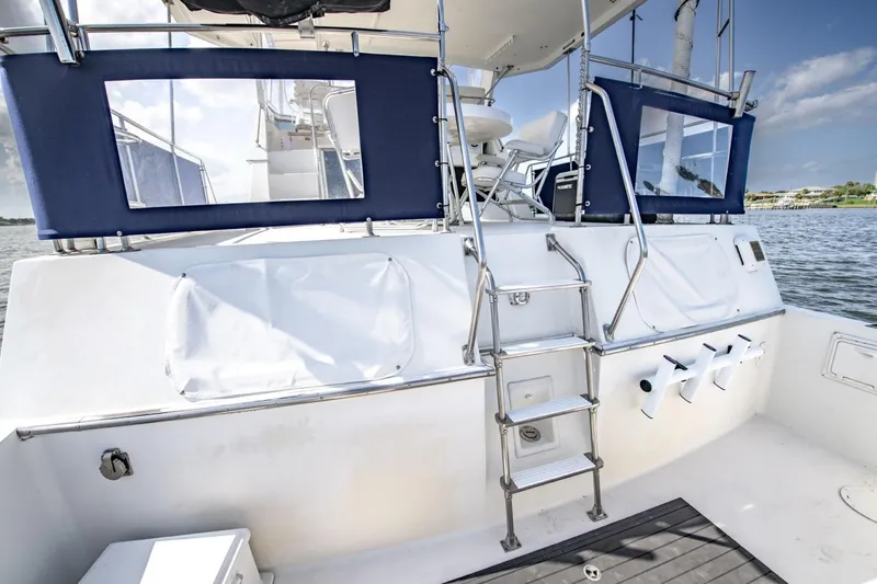 Slide: The Image of 1988 Tollycraft 44 Cockpit Motor Yacht with ladder and seating, docked on calm water. - 46