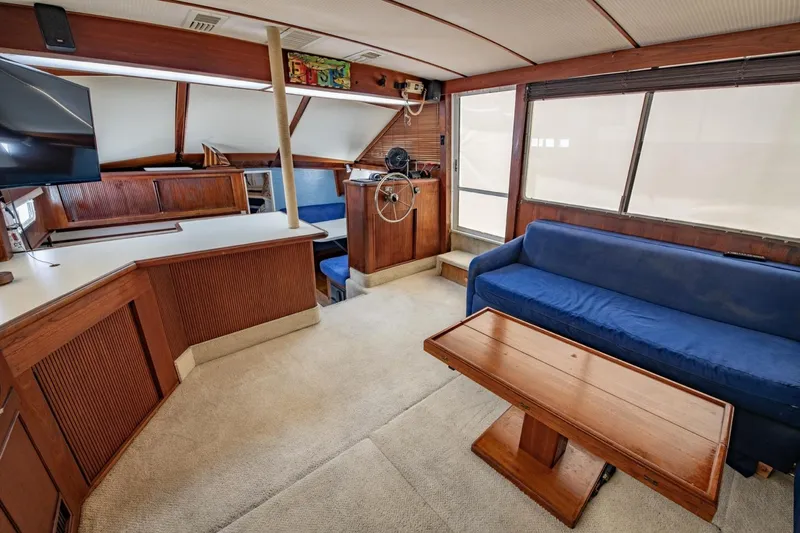 Slide: The Image of Interior of 1988 Tollycraft 44 Cockpit Motor Yacht with blue sofa and wooden accents. - 14