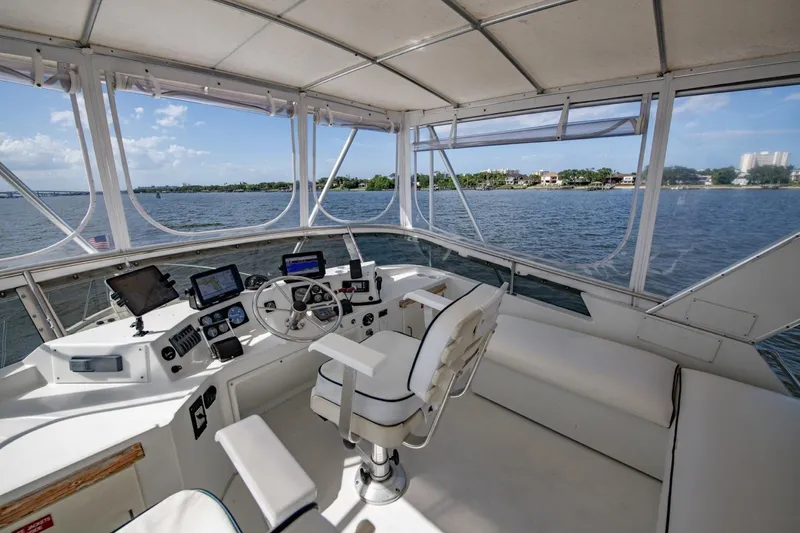 Slide: The Image of Cockpit view of 1988 Tollycraft 44 Motor Yacht with navigation equipment and scenic water backdrop. - 55
