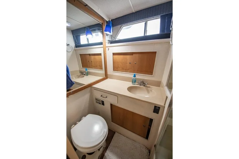 Slide: The Image of 1988 Tollycraft 44 Cockpit Motor Yacht bathroom with sink, mirror, and toilet. - 30