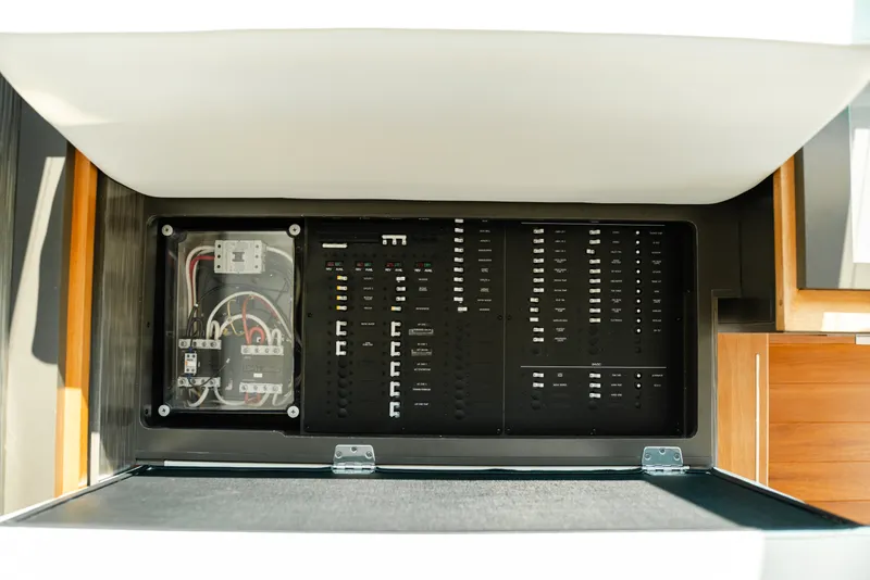 Slide: The Image of Electrical panel inside 2020 Tiara Yachts C49 Coupe, showcasing wiring and circuit breakers. - 49