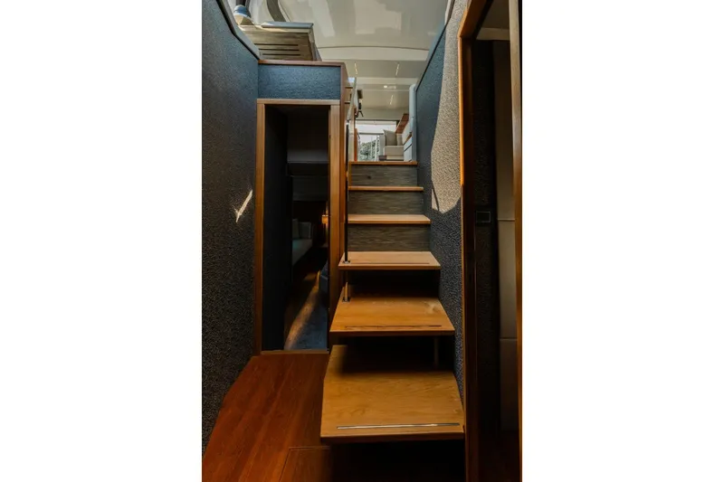Slide: The Image of Staircase inside 2020 Tiara Yachts C49 Coupe, featuring sleek wooden steps and modern design. - 26