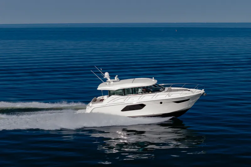Slide: The Image of 2020 Tiara Yachts C49 Coupe cruising on open water, showcasing sleek design and performance. - 8
