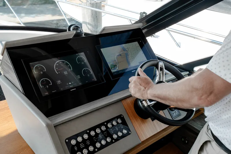 Slide: The Image of Helm of 2020 Tiara Yachts C49 Coupe with advanced navigation displays and controls. - 24
