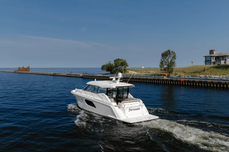 Slide: The Image of 2020 Tiara Yachts C49 Coupe cruising on a scenic waterway. - 7