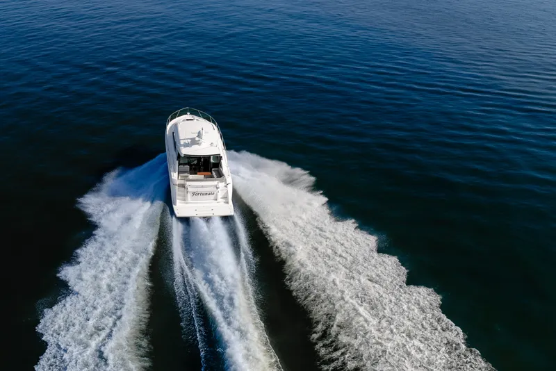 Slide: The Image of 2020 Tiara Yachts C49 Coupe cruising on open water, leaving a wake behind. - 9