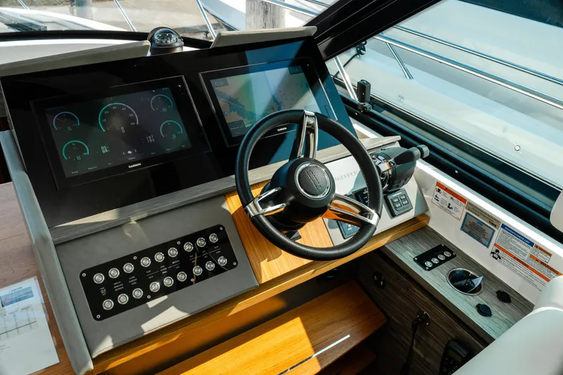 Slide: The Image of Helm of 2020 Tiara Yachts C49 Coupe with modern navigation displays and controls. - 23