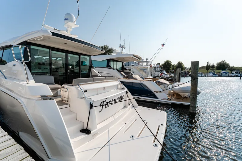 Slide: The Image of 2020 Tiara Yachts C49 Coupe docked at marina, sunny day, luxury boating. - 12
