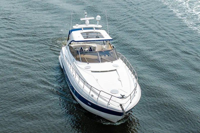 Slide: The Image of 2003 Cruisers 5470 Express yacht cruising on open water. - 15