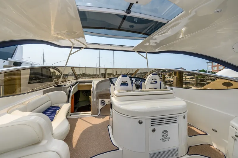 Slide: The Image of 2003 Cruisers 5470 Express yacht interior with helm, seating, and open sunroof. - 30