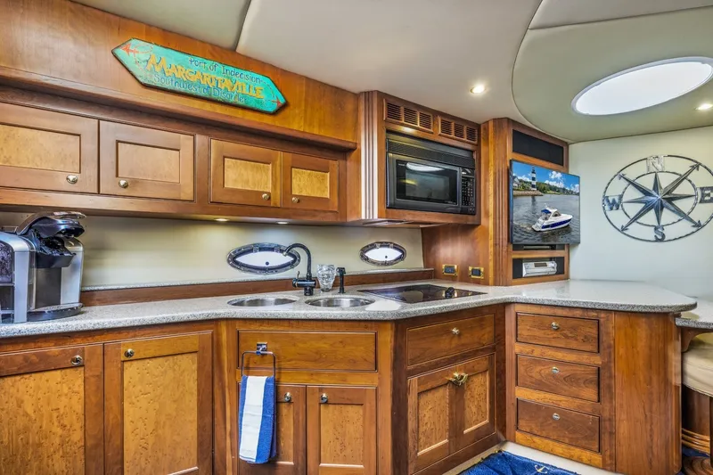 Slide: The Image of Luxurious 2003 Cruisers 5470 Express yacht kitchen with wood cabinetry and modern appliances. - 55