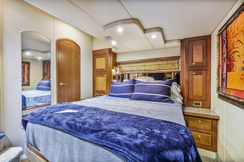 Slide: The Image of Luxurious bedroom interior of 2003 Cruisers 5470 Express yacht with elegant wood cabinetry. - 44