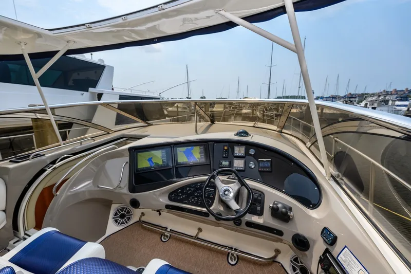 Slide: The Image of 2003 Cruisers 5470 Express yacht helm with navigation screens and steering wheel. - 33