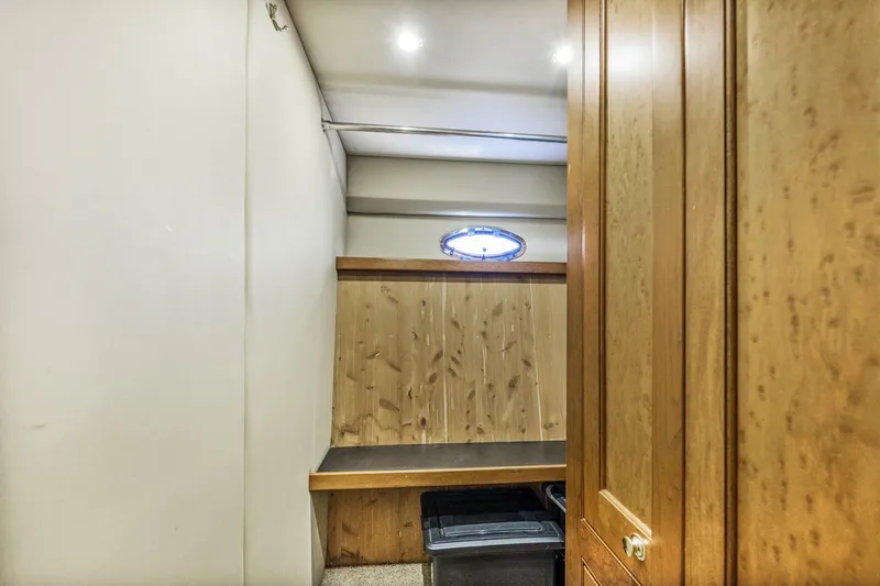 Slide: The Image of Interior cabin of 2003 Cruisers 5470 Express yacht with wooden paneling and small window. - 47