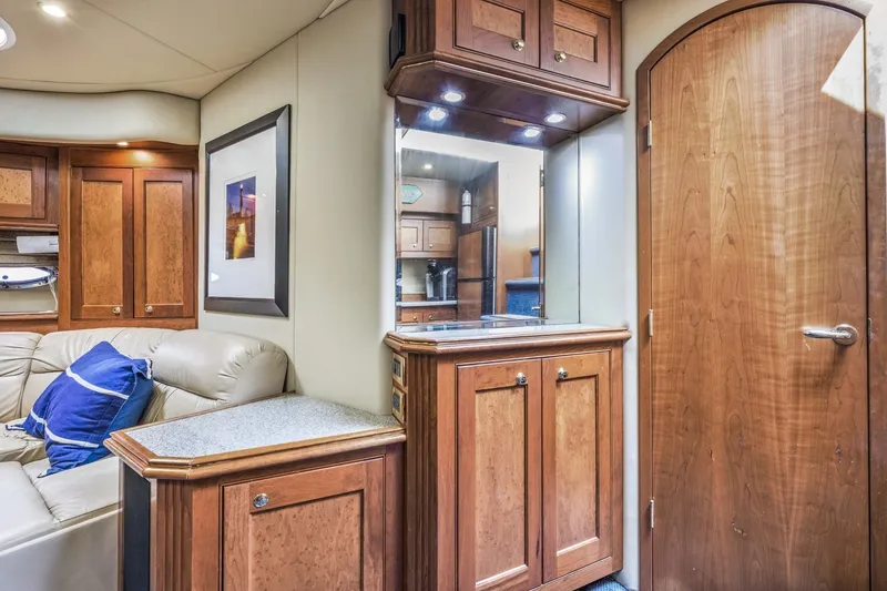Slide: The Image of Interior of 2003 Cruisers 5470 Express yacht with wood cabinetry and beige seating. - 56