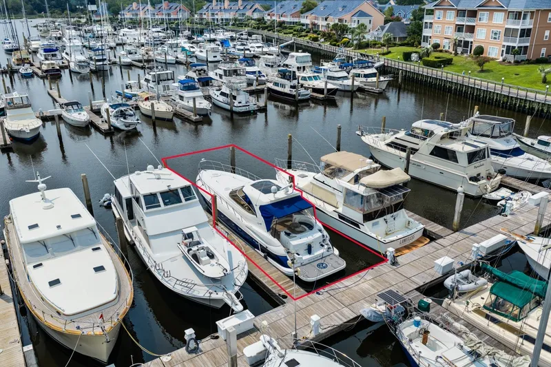 Slide: The Image of 2003 Cruisers 5470 Express yacht docked at a marina surrounded by other boats. - 18
