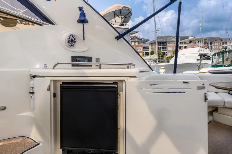 Slide: The Image of 2003 Cruisers 5470 Express yacht interior with mini fridge and seating area. - 26