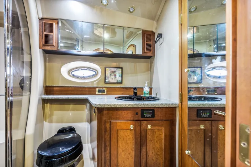 Slide: The Image of Luxurious bathroom interior of 2003 Cruisers 5470 Express yacht with wooden cabinetry and modern fixtures. - 50