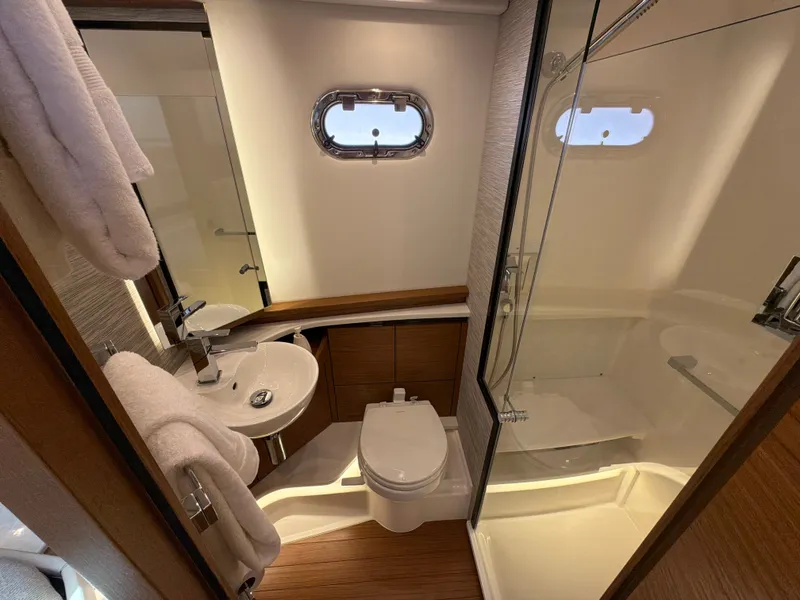 Slide: The Image of The image shows an elegant yacht bathroom with a shower, sink, and toilet. - 33