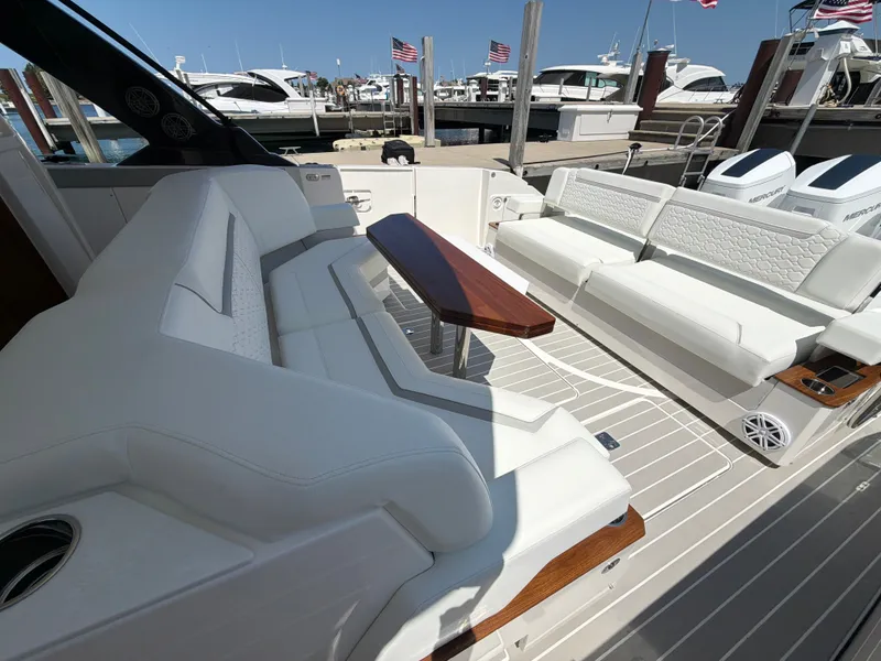 Slide: The Image of The image shows the cockpit of a 2026 Tiara Yachts 48 LS with luxurious white seating and a wooden table. - 19