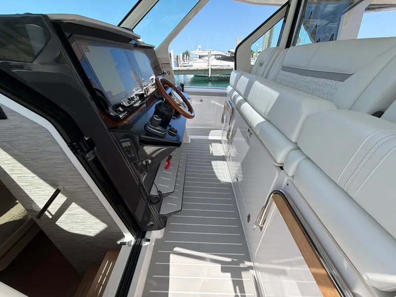 Slide: The Image of The image shows the cockpit of a 2026 Tiara Yachts 48 LS with luxurious white seating and a modern helm. - 29
