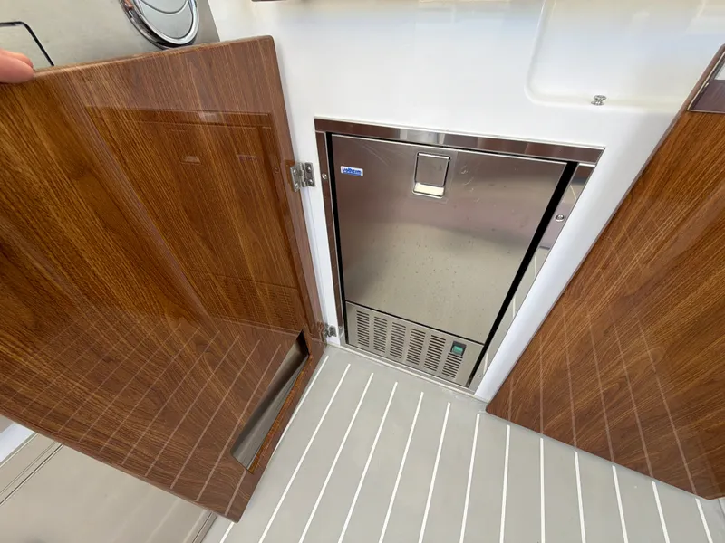 Slide: The Image of A sleek interior with wooden doors and a built-in stainless steel refrigerator on a boat. - 24