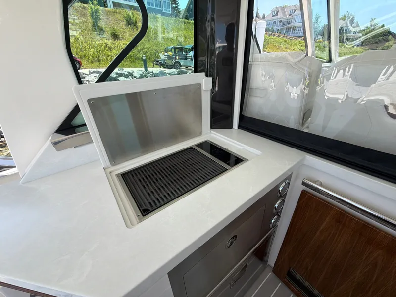 Slide: The Image of The 2026 Tiara Yachts 48 LS features a sleek outdoor kitchen with a grill and storage space. - 27