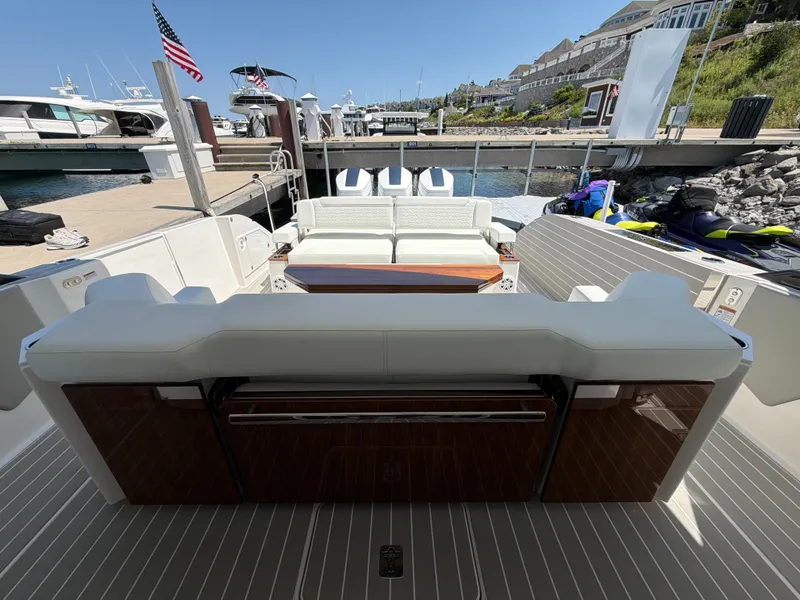 Slide: The Image of The image shows the stern of a 2026 Tiara Yachts 48 LS docked. It features seating and a clear view of the water. - 16