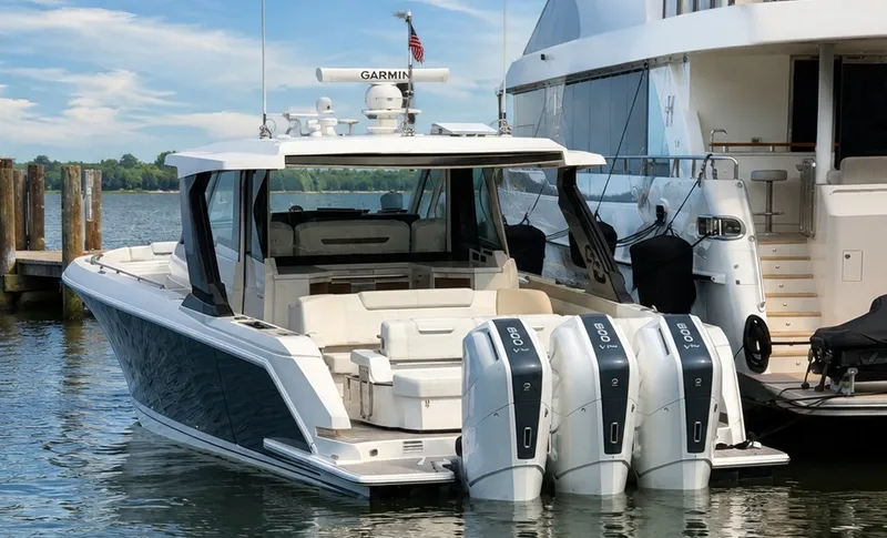 Slide: The Image of A luxurious 2026 Tiara Yachts 48 LS docked, featuring three outboard engines. - 1