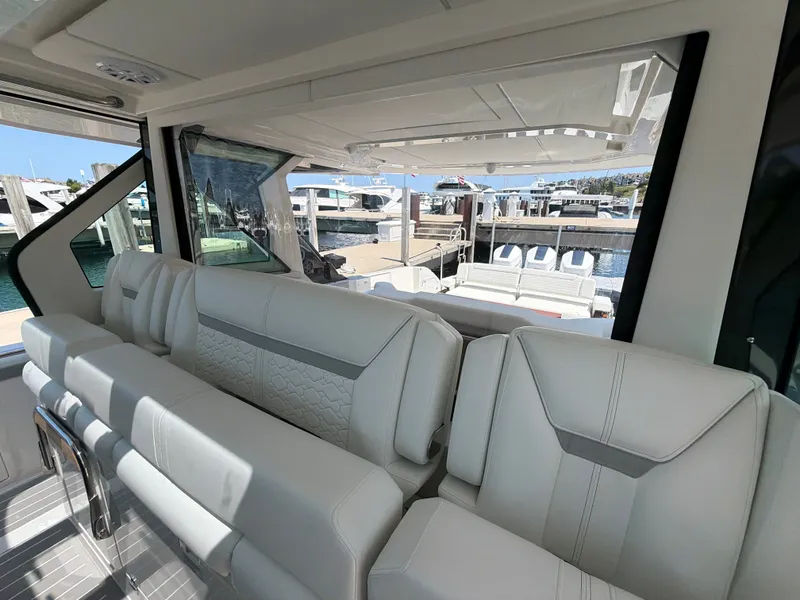 Slide: The Image of Interior view of a luxury yacht with white leather seating and large windows overlooking a marina. - 38