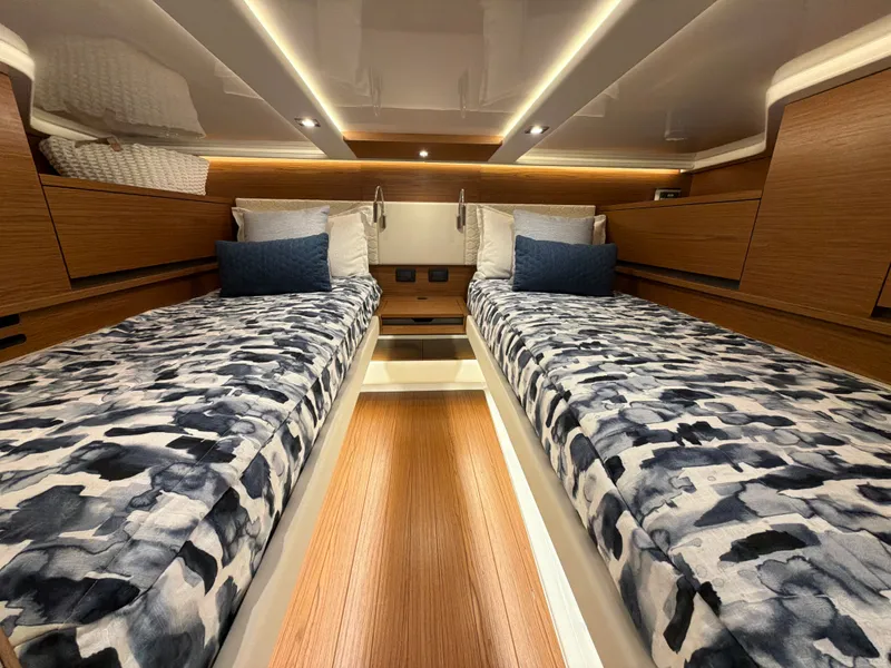 Slide: The Image of The 2026 Tiara Yachts 48 LS cabin features two single beds with patterned covers. - 35