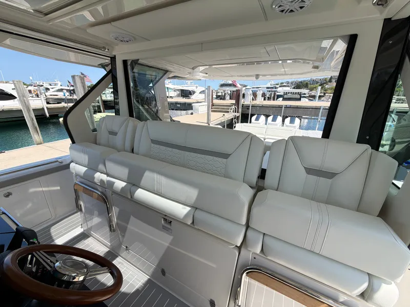 Slide: The Image of The image shows the luxurious cockpit of a 2026 Tiara Yachts 48 LS with white leather seating. - 12