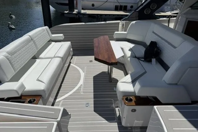 Slide: The Image of The image shows the cockpit of a 2026 Tiara Yachts 48 LS with sleek white seating and a wooden table. - 44