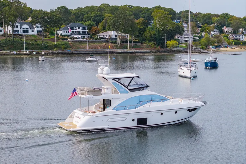 Slide: The Image of Azimut Fly 50 yacht cruising on a serene lake, surrounded by sailboats and lush greenery. - 7