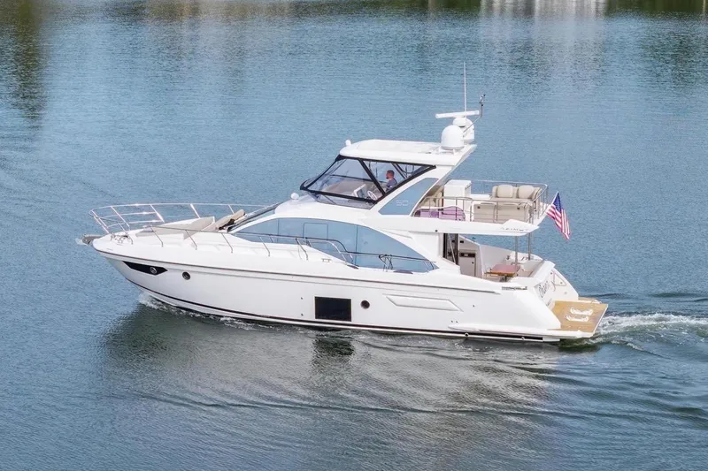 The Image of 2020 Azimut Fly 50 yacht cruising on a calm lake with lush greenery. - 0