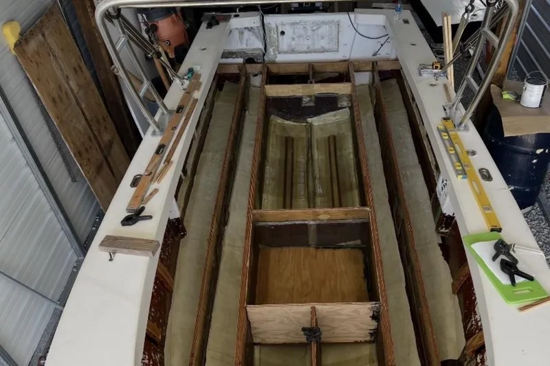Slide: The Image of 2022 May-Craft 2000 CC boat under restoration in a workshop setting. - 11