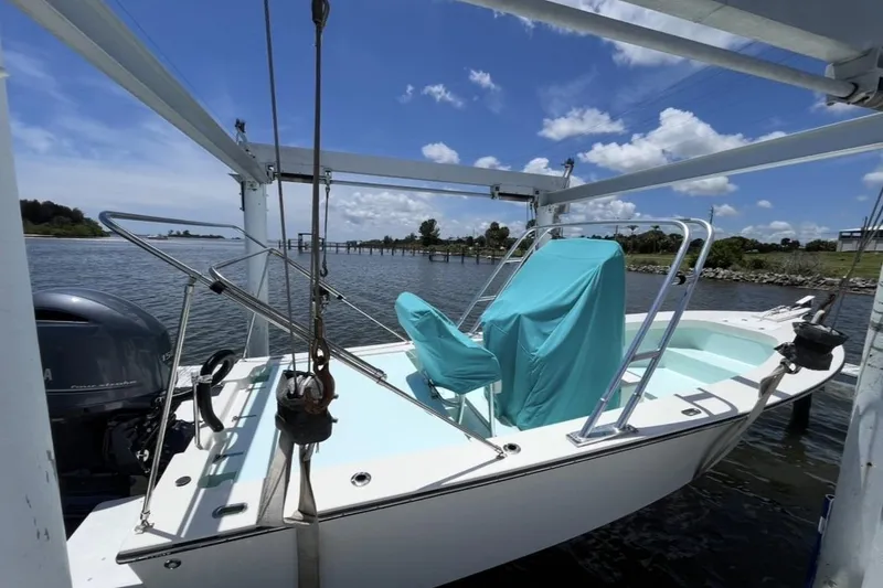 Slide: The Image of 2022 May-Craft 2000 CC boat on lift, covered seats, scenic waterfront view. - 5