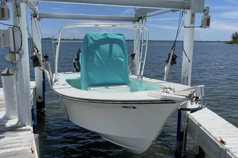 Slide: The Image of 2022 May-Craft 2000 CC boat on lift, docked by the water. - 2