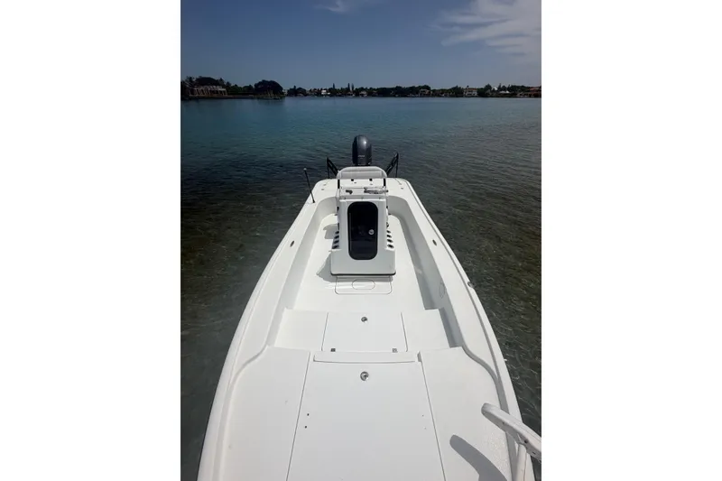 Slide: The Image of 2019 Yellowfin 21 Bay boat on calm water, showcasing sleek design and spacious deck. - 9