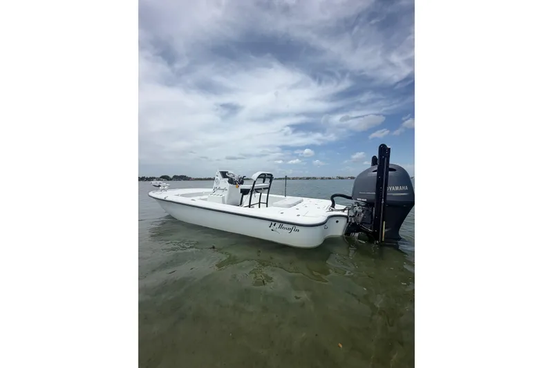 Slide: The Image of 2019 Yellowfin 21 Bay boat with Yamaha engine on calm water under cloudy sky. - 2